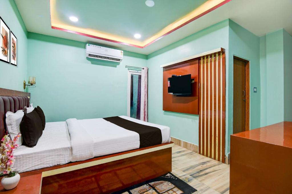 a bedroom with a bed and a tv on the wall at Hotel O GALAXY in Jagatpur