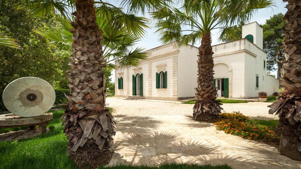 budynek z palmami przed nim w obiekcie Villa Galluccio with swimming pool w mieście Galatina