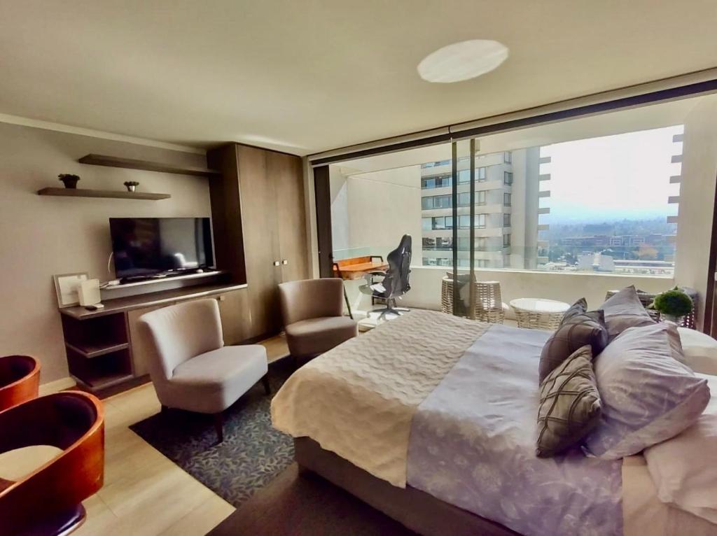 a bedroom with a large bed and a large window at Exclusive and Secure Apartment Parque Arauco Las Condes in Santiago