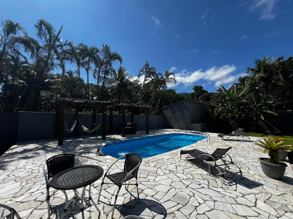 eine Terrasse mit Stühlen und einem Swimmingpool in der Unterkunft Sunset Maresias- Casas e Chalés C1 in Maresias