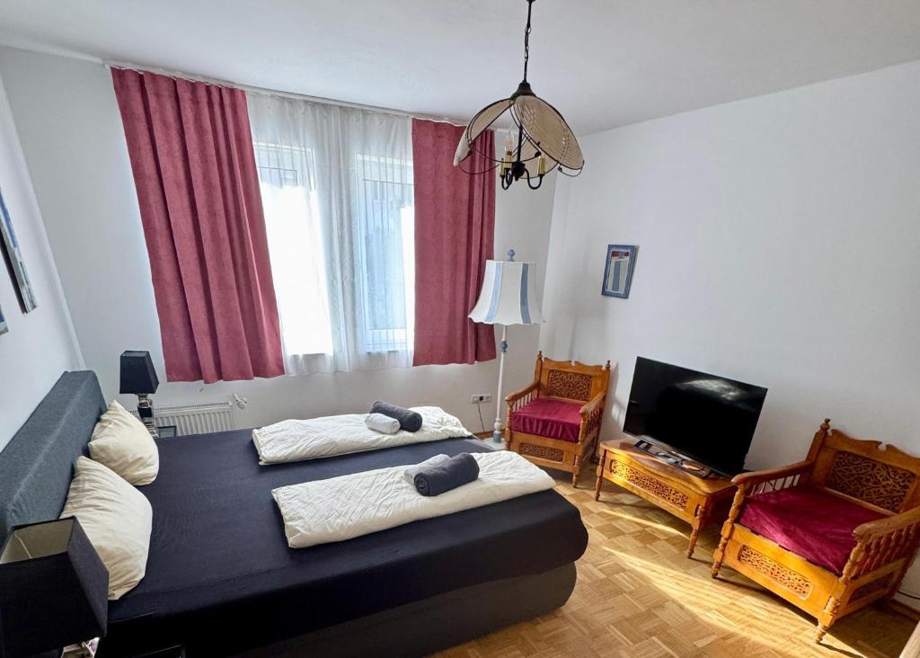 Un dormitorio con dos camas y un televisor de pantalla plana. en Altstadt Apartmenthaus, en Kassel