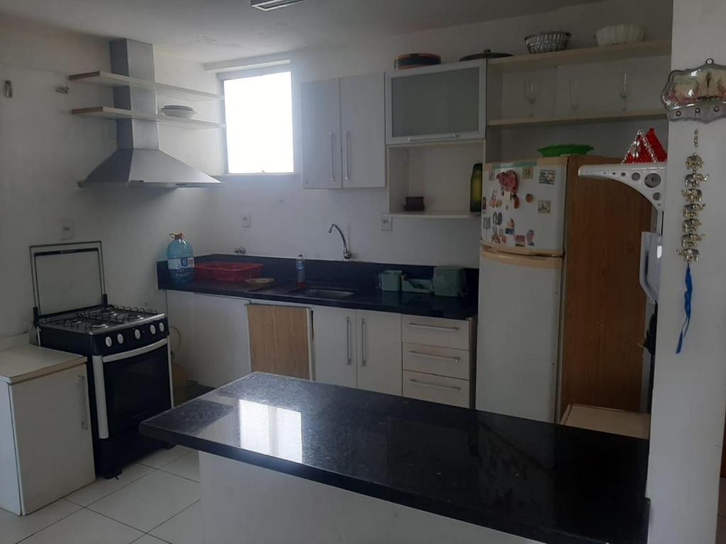 una cucina con mobili bianchi e un piano di lavoro nero di Edifício Paes de Carvalho cop 30 a Belém