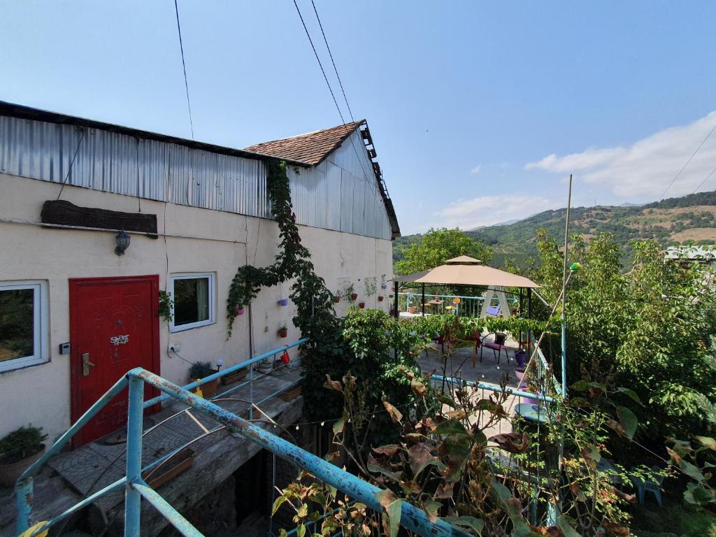 a building with a red door next to a yard at Sweet Home 2 in Dilijan