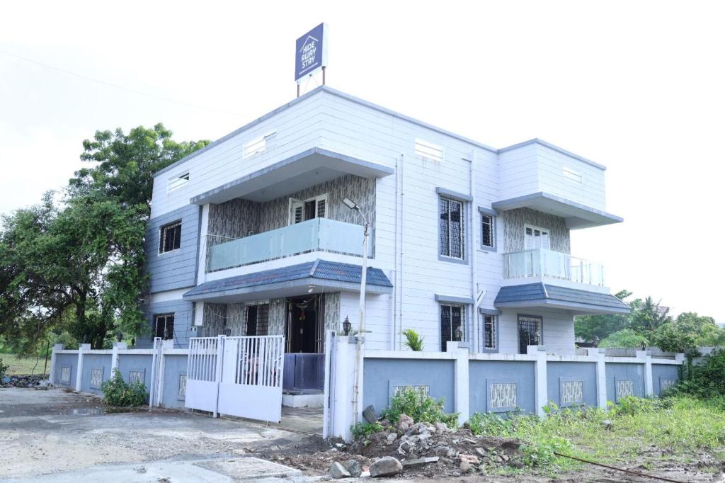 a white building with a fence in front of it at Hide away stay in Pune
