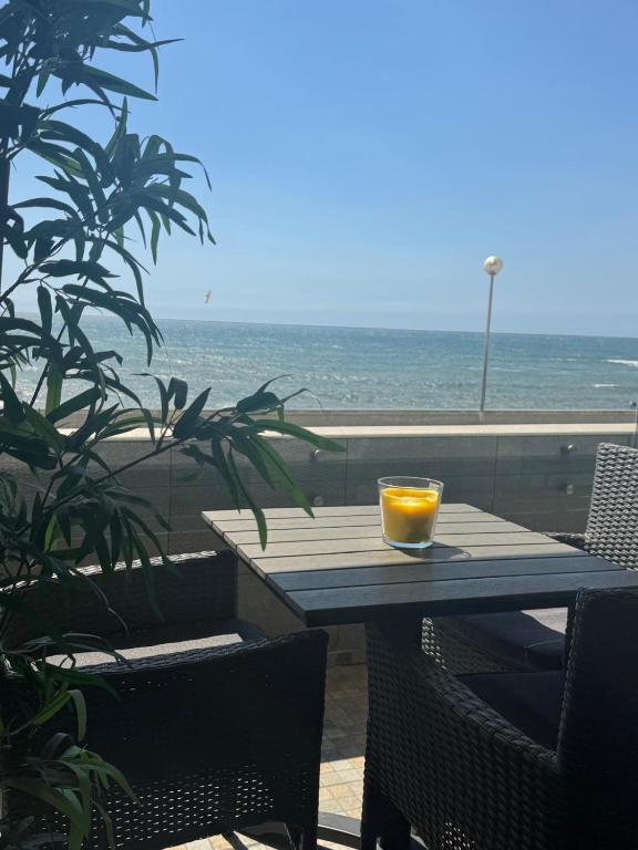 a table with a glass of orange on top of it at Aver Beach Haven in Póvoa de Varzim