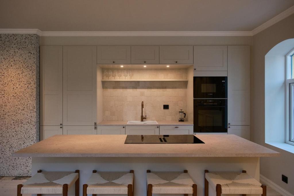 a kitchen with a large island with chairs in it at Large city apartment with sea view and parking in Ålesund
