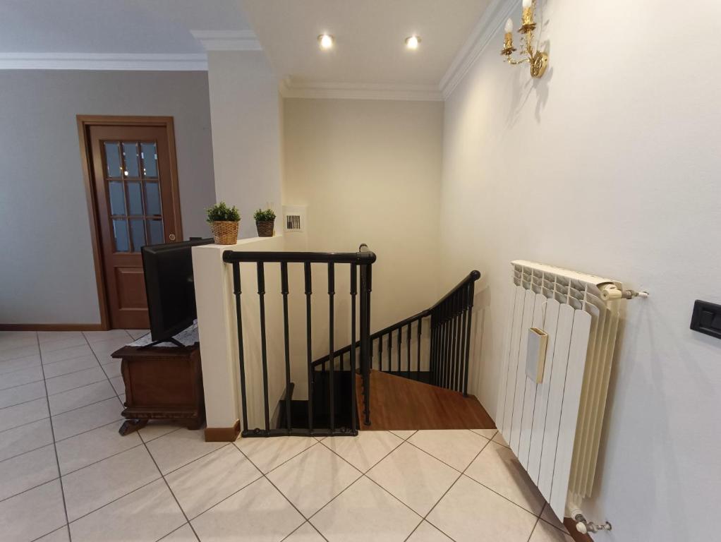pasillo con escalera y TV en la habitación en Barbara House, en Tribiano
