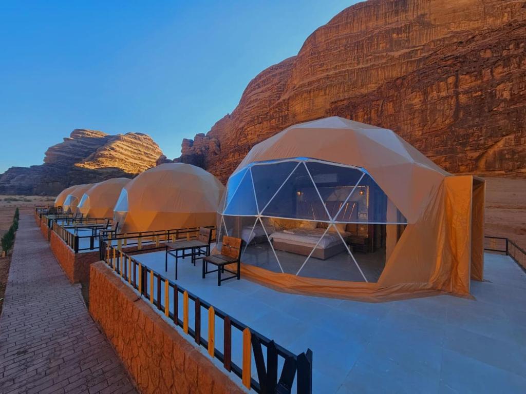 a row of tents lined up in the desert at Wadi Rum Hakuna Matata Camp and Jeep Tour in Disah