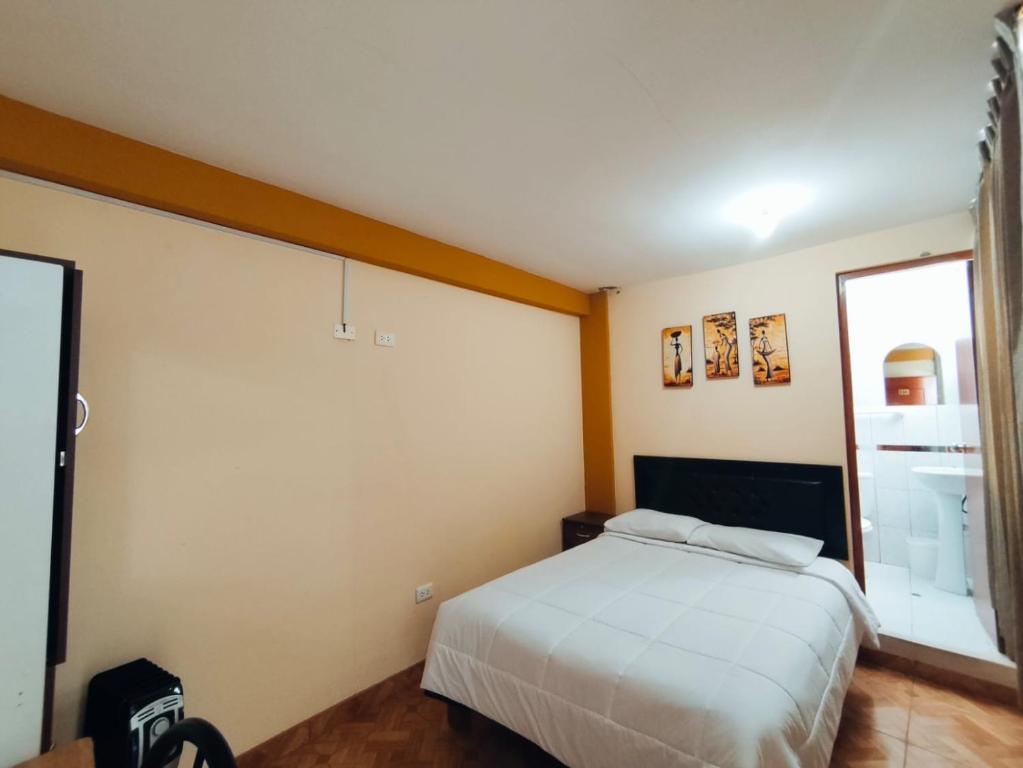 a bedroom with a white bed and a window at Posada de Zarita in Chivay