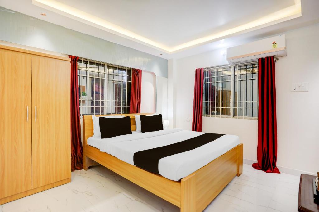 ein Schlafzimmer mit einem Bett und zwei Fenstern in der Unterkunft Hotel O Sagar Luminoire Hotel & Banquet Hall in Gulzārbāgh