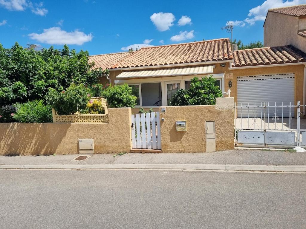 una casa con un cancello bianco e una recinzione di Villa l'Oranger a Sigean