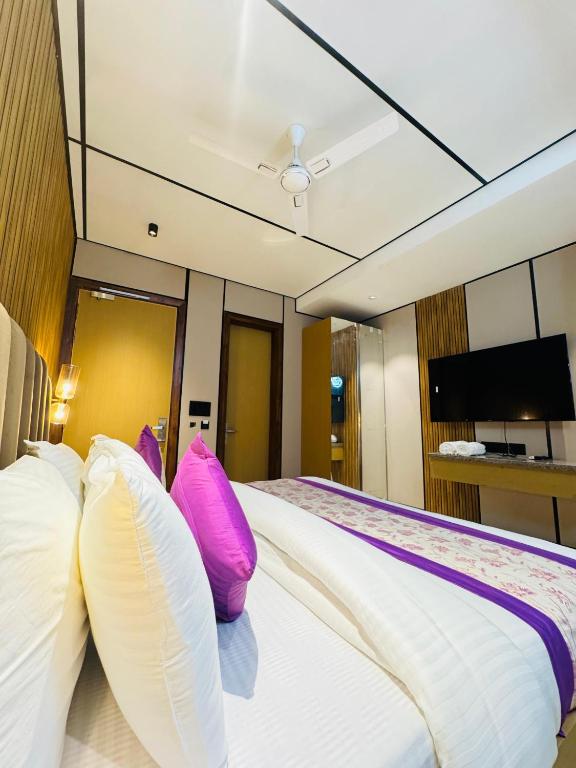 a bedroom with a large bed with pink pillows at JS Residency Luxe Collection Hotel Near Nizamuddin Railway Station in New Delhi