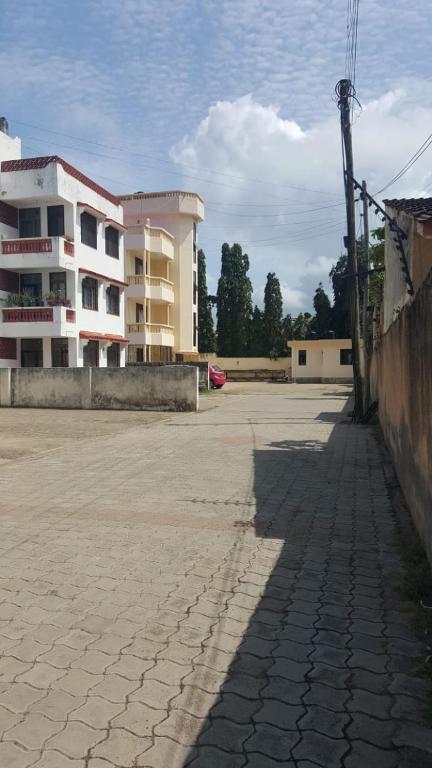 a parking lot with a large building in the background at Rose homes in Mombasa
