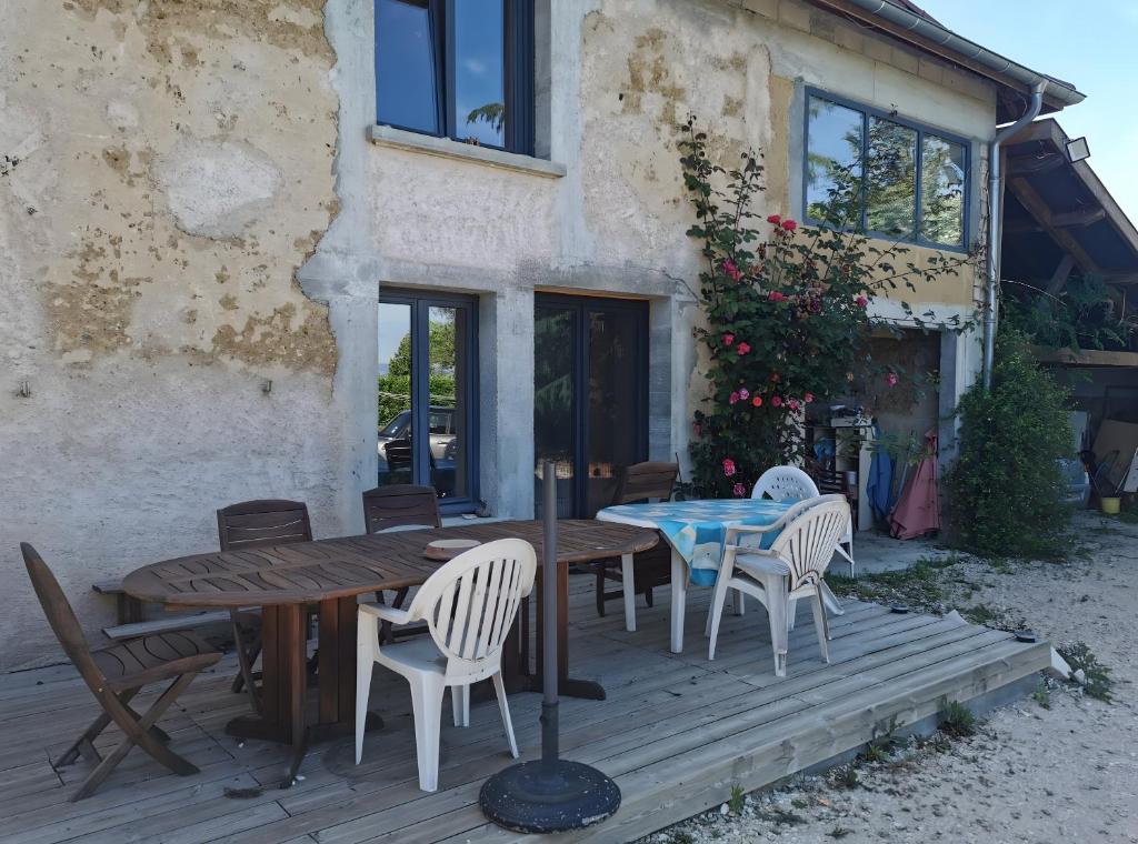 Faverges-de-la-TourにあるGîte Studioの木製デッキ(テーブル、椅子付)