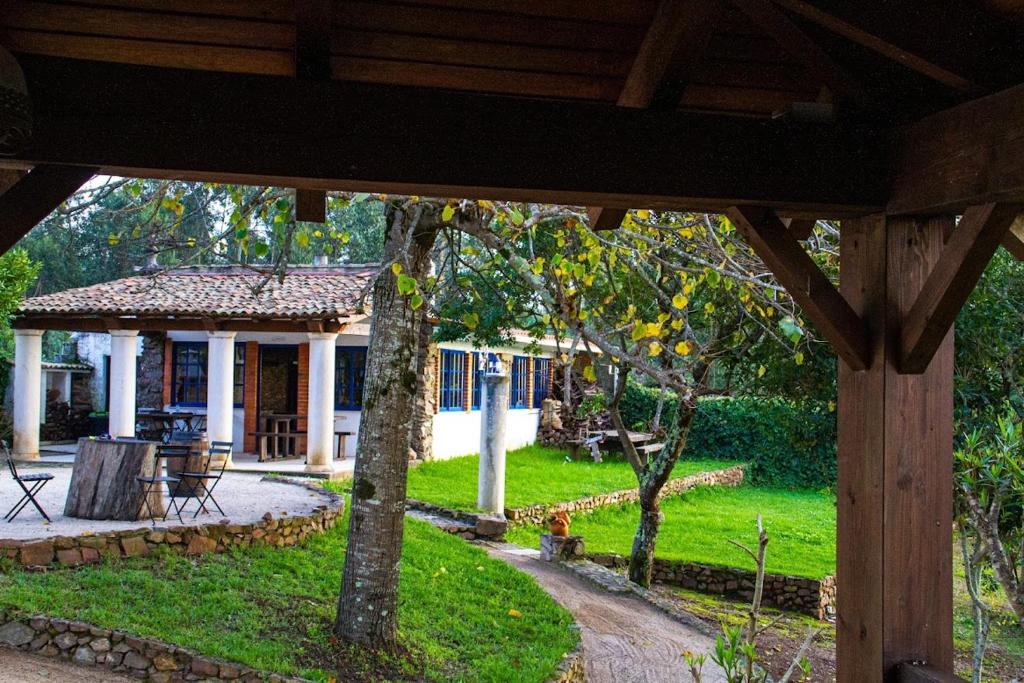 a view of a house from under a wooden pavilion at O Moinho de Vale da Mó in Anadia