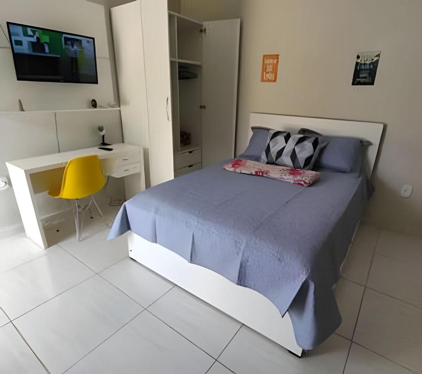 una camera da letto con un letto, una scrivania e una televisione di kitnet Mobiliado apto 107 a Rio Branco