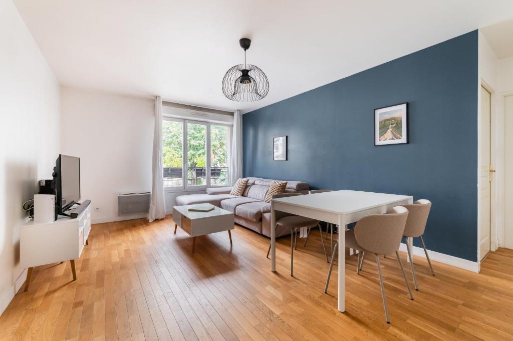 3 pièces proche de Paris avec terrasse et parking في شاتيلون: غرفة معيشة بها أريكة وطاولة