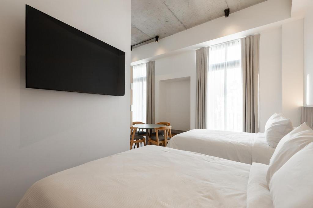 a hotel room with two beds and a flat screen tv at Cayalá Hospitalidad in Guatemala