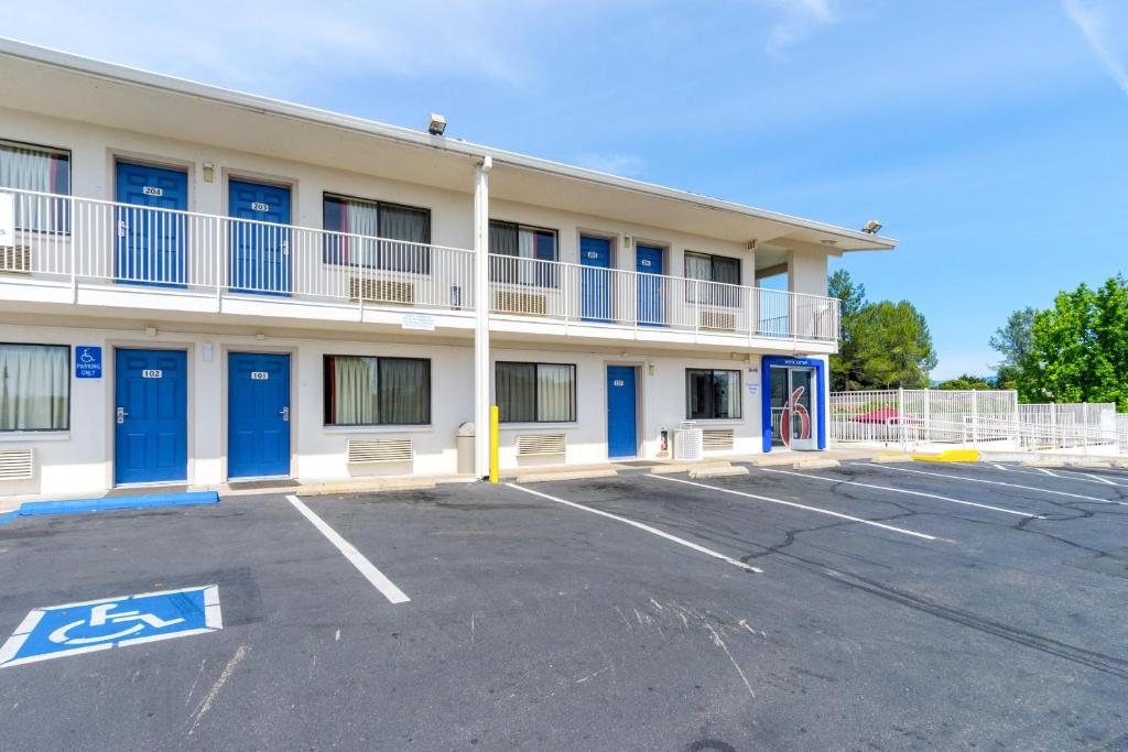 a building with blue doors in a parking lot at Motel 6-Redding, CA - Central in Redding