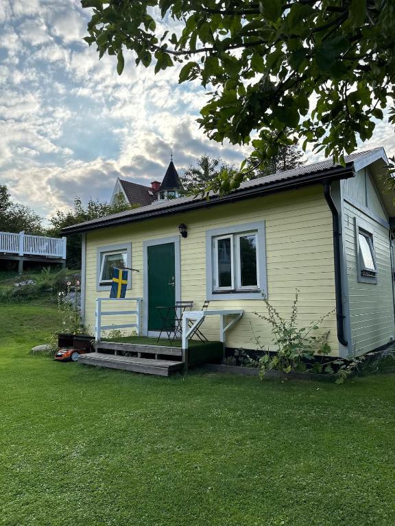 a small house with a green door on a yard at Small Seaside Cottage in Saltsjöbaden