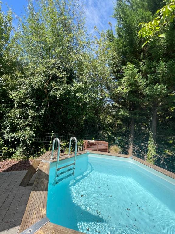 a swimming pool with a bench next to it at Studio cosy avec piscine privative in Saint-Sernin