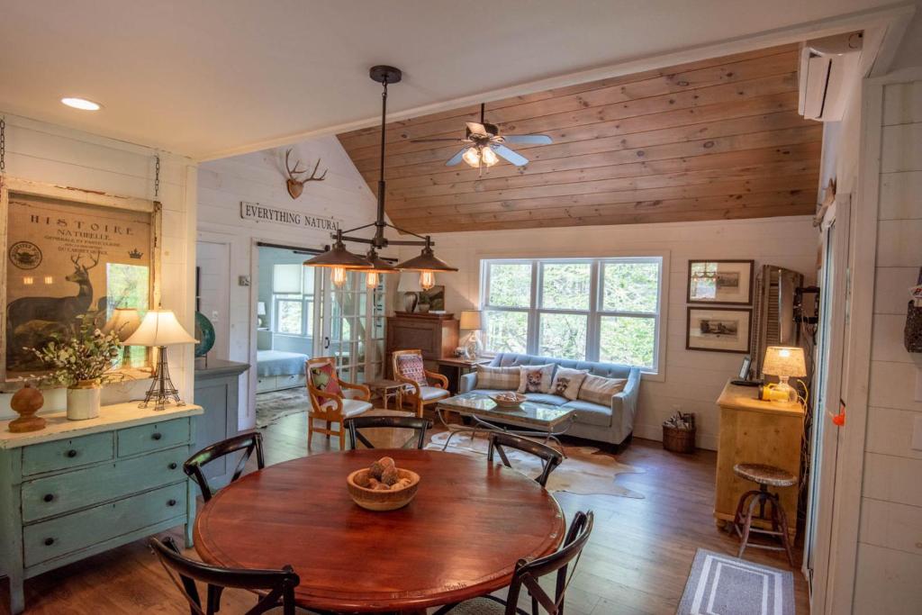 a dining room and living room with a table and chairs at Sweetwater Cottage - Private Cottage Tucked in the Woods - WJ & Boone - River Access in West Jefferson