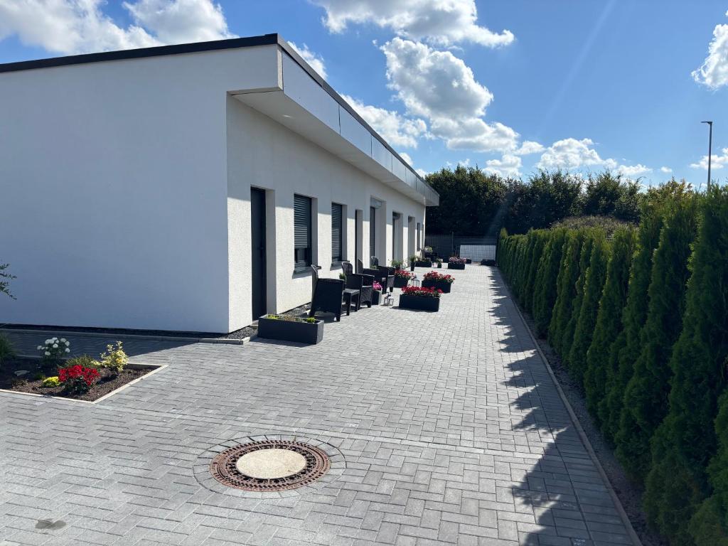 a white building with a row of chairs on a patio at A7 Apartment 3 in Dätgen