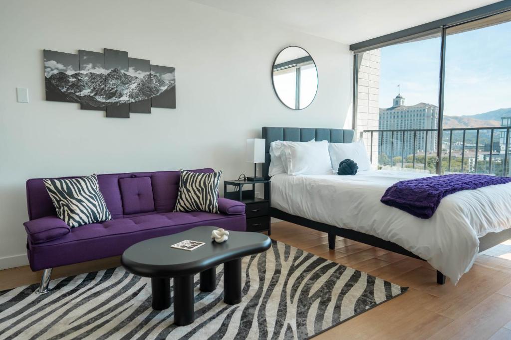 a bedroom with a purple bed and a purple couch at Cityscape Peaks Penthouse DT Gym Free parking in Salt Lake City