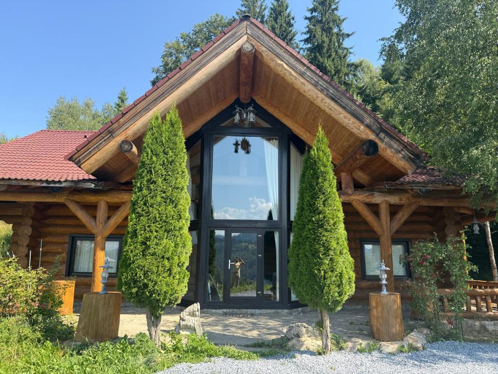 a log cabin with a large glass door at Mi Chalet - Poiana Izvoarelor in Vatra Dornei
