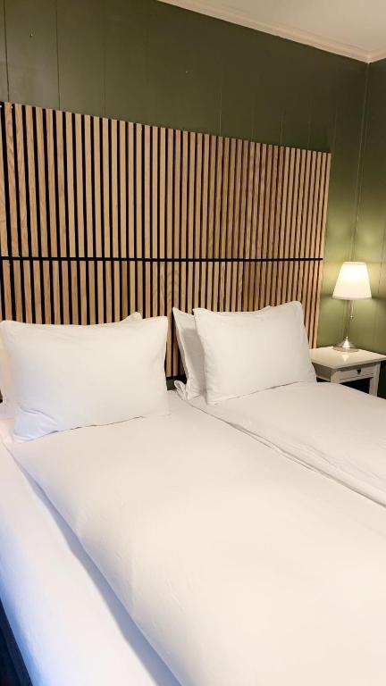 a bed with two white pillows in a bedroom at Spacious 3BR Apartment - Fast Wi-Fi - Free Parking - Near Oslo Airport & City - Les Homes in Gjerdrum