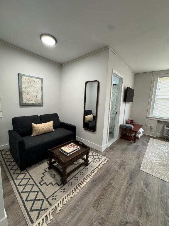 a living room with a black couch and a table at Yale Casa Blanco in New Haven