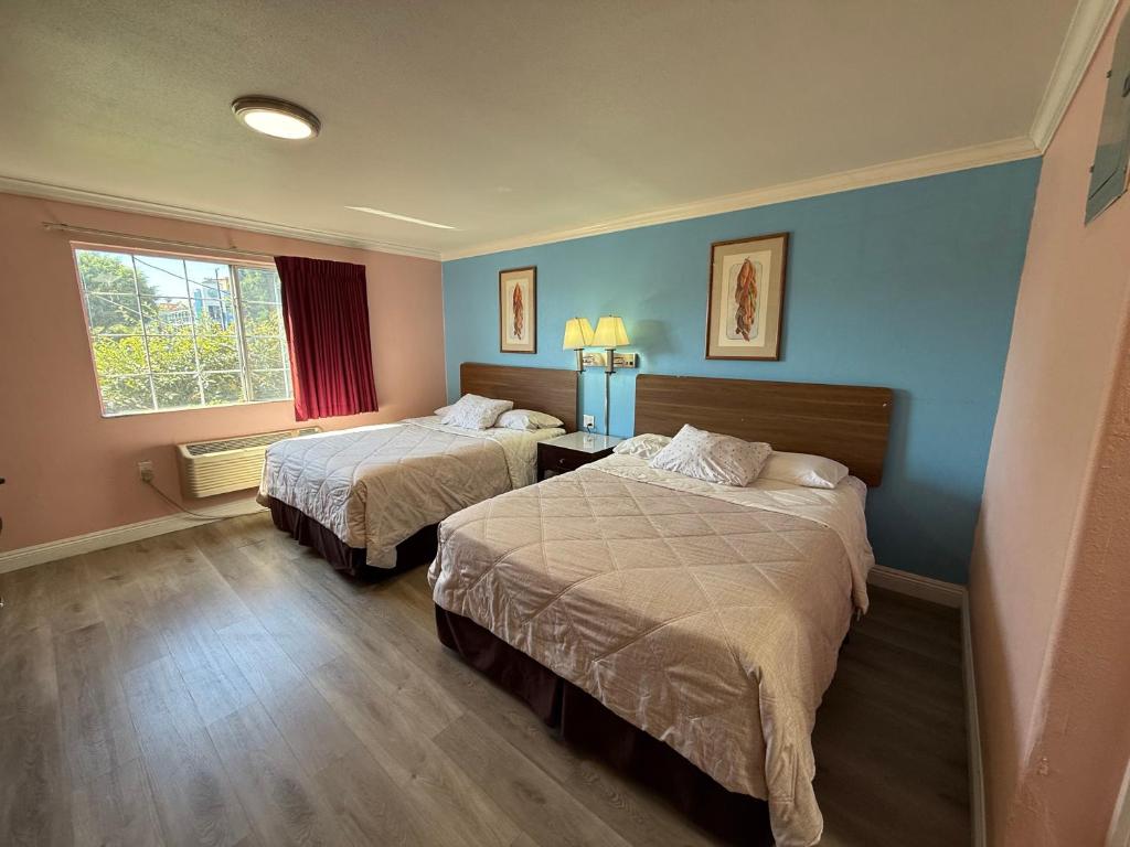 a hotel room with two beds and a window at Travel Inn Downtown LA in Los Angeles