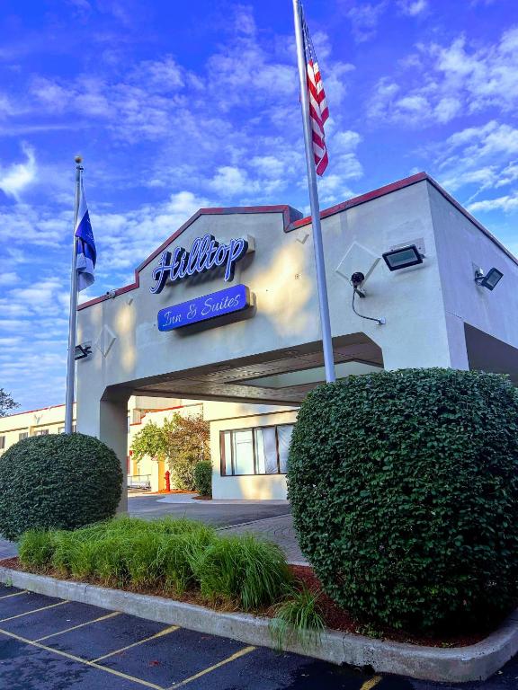 Un edificio con dos banderas delante. en Hilltop Inn &amp; Suites, en Yonkers