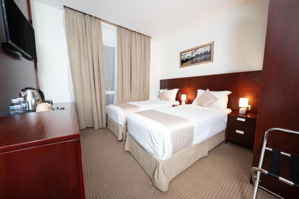 a hotel room with two beds and a television at فندق ديمورا Dimora Hotel in Makkah