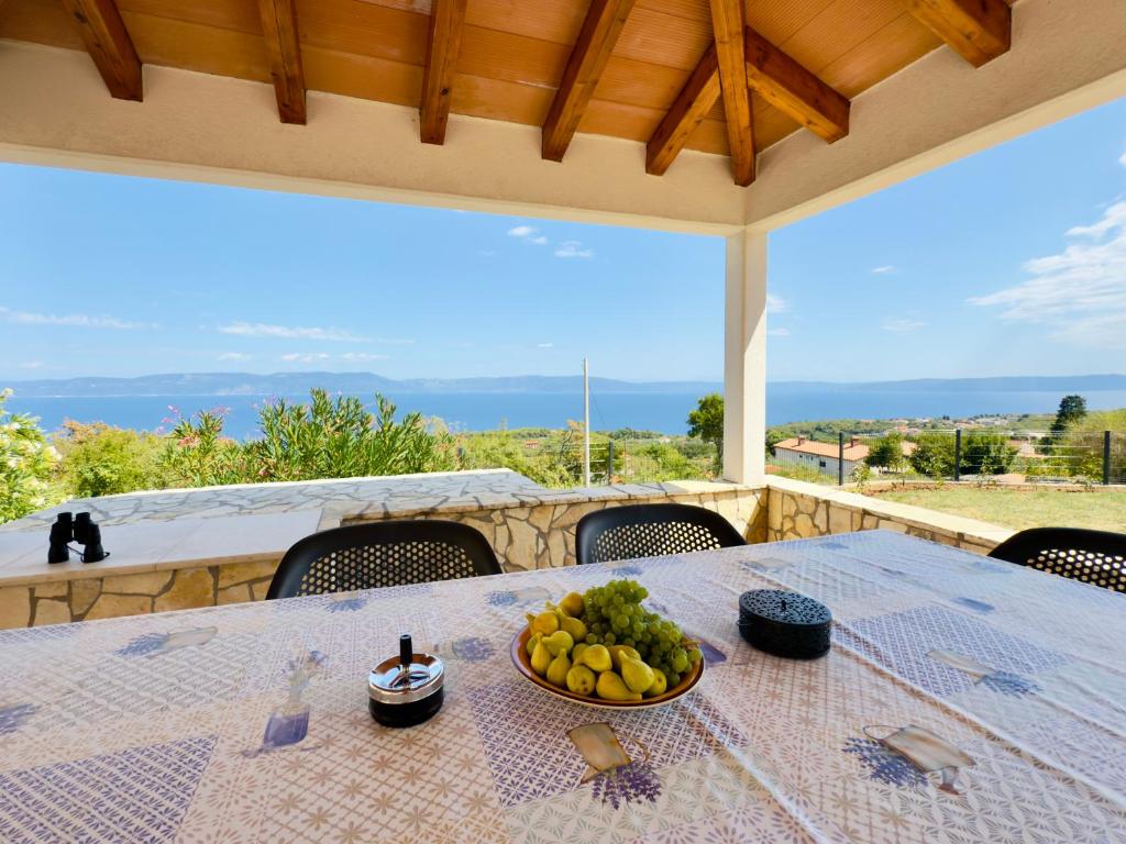 a bowl of fruit on a table on a patio at Stone House Sea View Vista Natura Private Garden Quiet Location in Labin