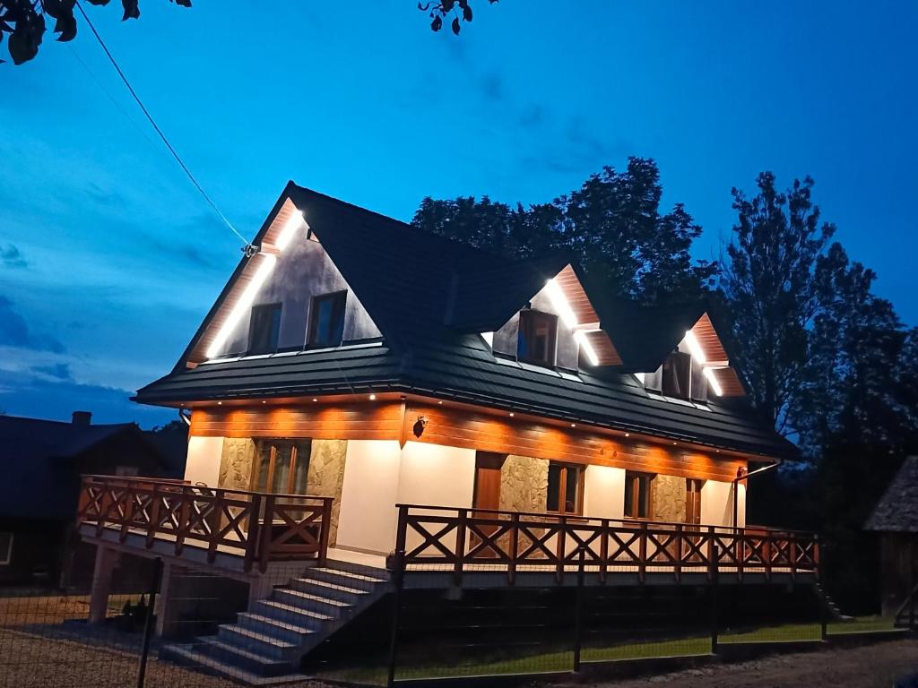 a house with lights on the front of it at Między Górami in Korbielów