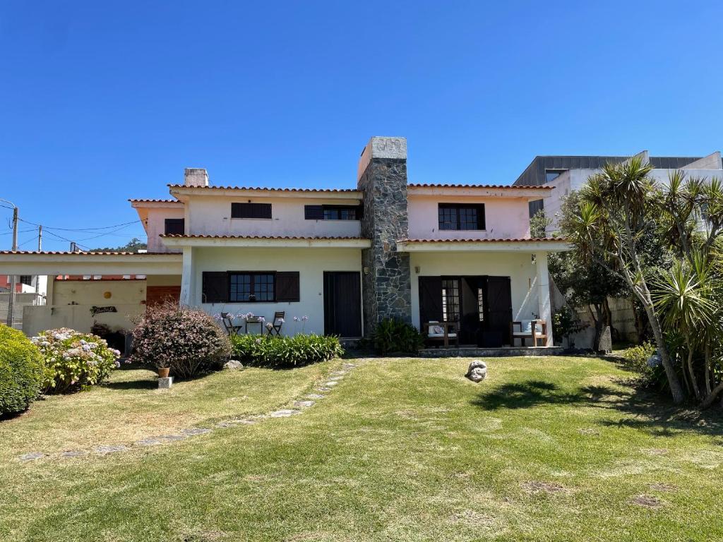 ein großes Haus mit einem Vorgarten in der Unterkunft First-Line Oceanfront House in Moledo in Moledo