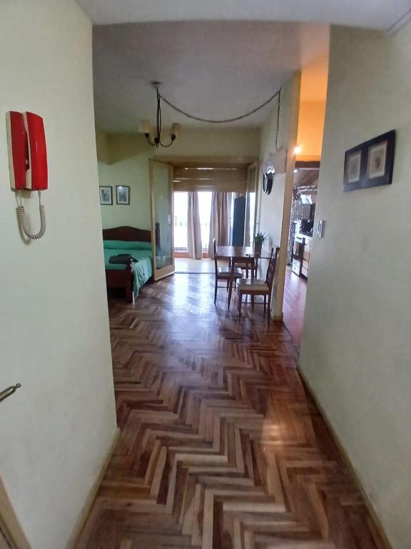 a living room with a wooden floor and a table at carmon colon 1 ambiente y medio in Mar del Plata
