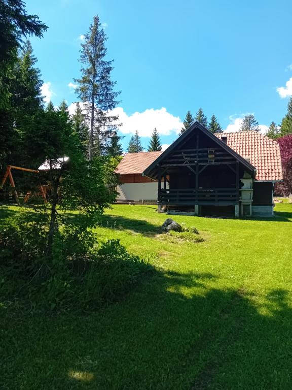 a house in a yard with a green lawn at Brvnara Vidikovac in Bajina Bašta