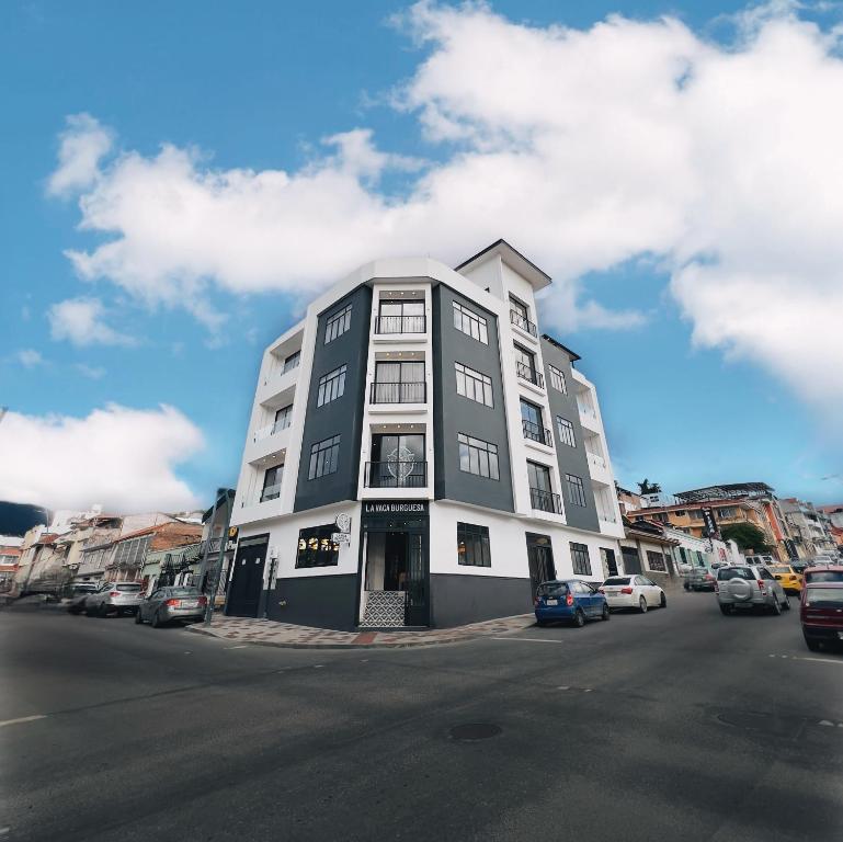 a tall white building on the side of a street at Sofisticado Departamento Central en Loja in Loja