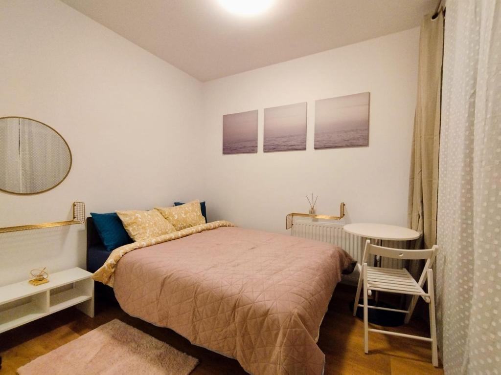 Solidarnosci155GuestRooms في وارسو: غرفة نوم صغيرة مع سرير وطاولة