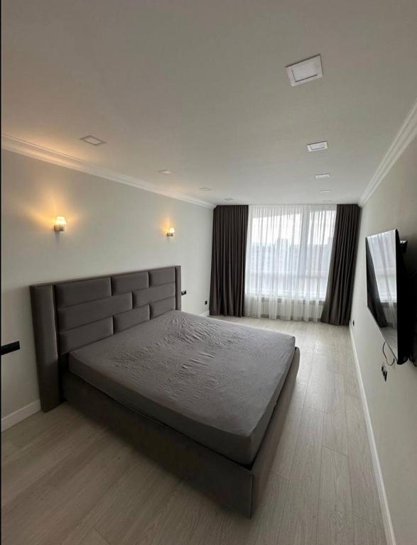 una camera da letto con un letto grande e una finestra di ApartHotel city centrum a Chişinău
