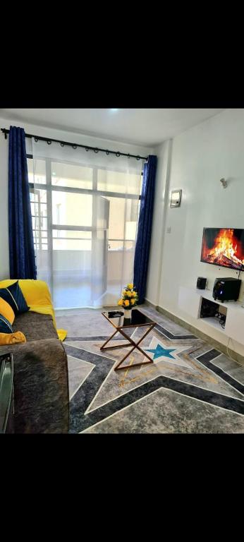 Μια τηλεόραση ή/και κέντρο ψυχαγωγίας στο TVHStays Cozy 1-BEDROOM Roysambu