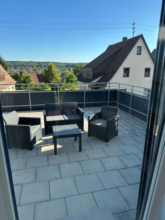 a patio with couches and a table and chairs at Guest House BiBi-Lux in Ilsfeld