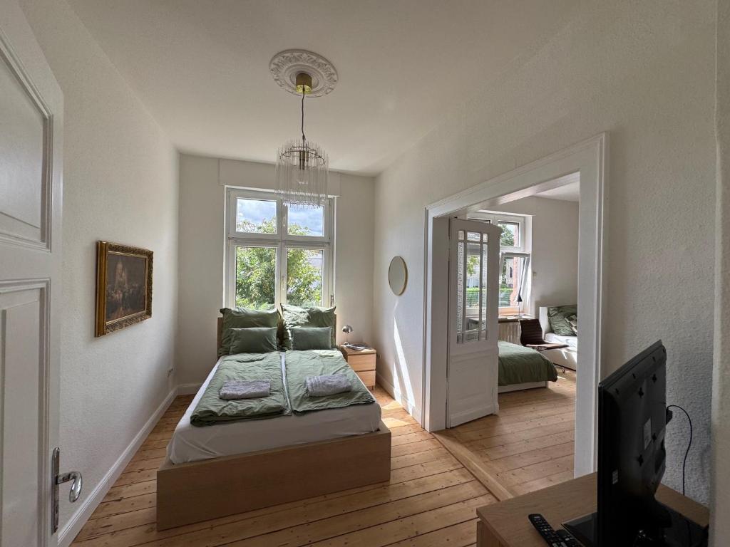 une chambre avec un lit, une fenêtre et une télévision dans l'établissement Grand Apartment Worms - Stilvolles Wohnen im Zentrum, à Worms