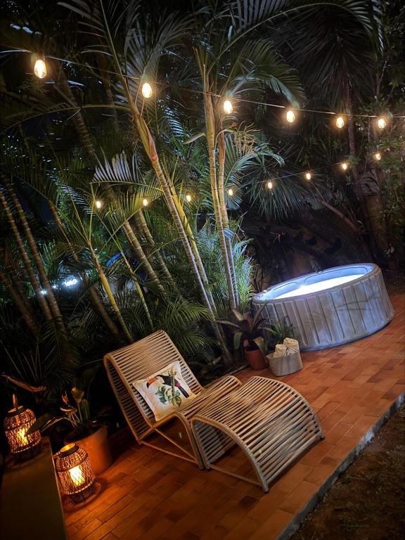 a chair on a patio with palm trees and lights at Pousada São Jorge in Bonito
