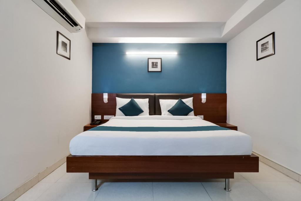 维沙卡帕特南Super Hotel O Stay Inn Maharani Peta的卧室里有一张床，墙壁是蓝色的