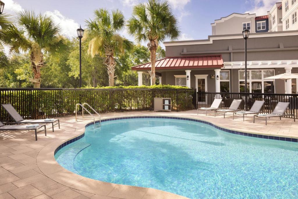 Una piscina con tumbonas al lado de un edificio. en Residence Inn Tampa Suncoast Parkway at NorthPointe Village, en Lutz