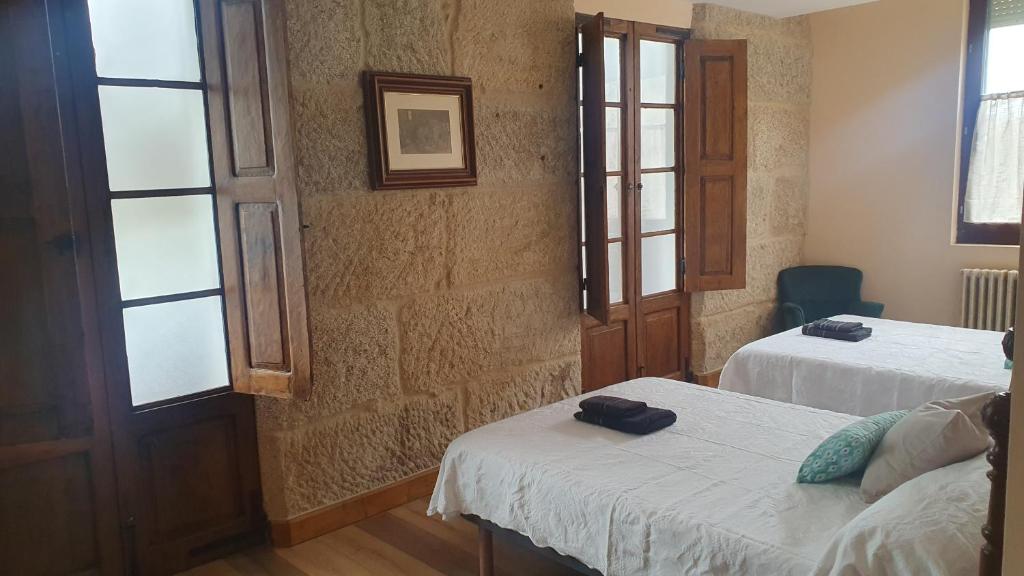 a room with two beds and two windows at Casa San Amaro in San Amaro