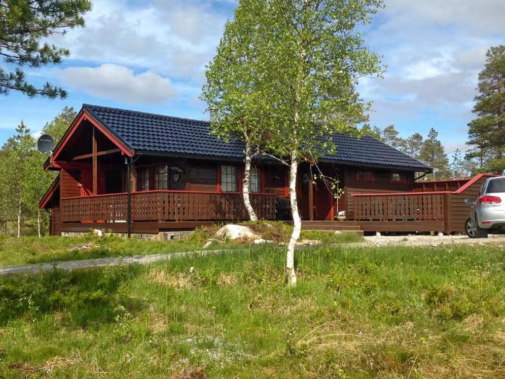 a log cabin with a car parked in front of it at Renovated Cabin By Lake Djupedal in Bygstad